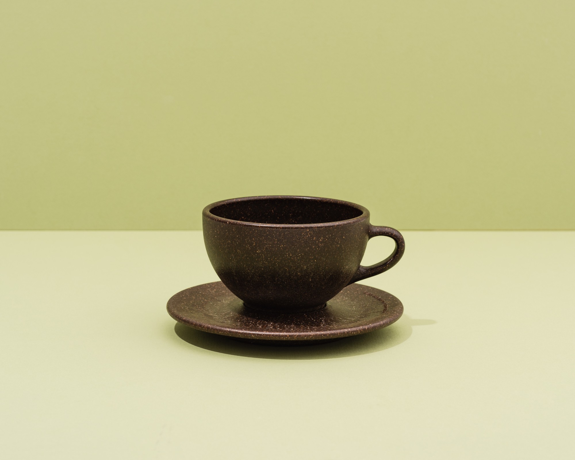 Kaffeeform Latte Cup mit Untertasse mit grünem Hintergrund