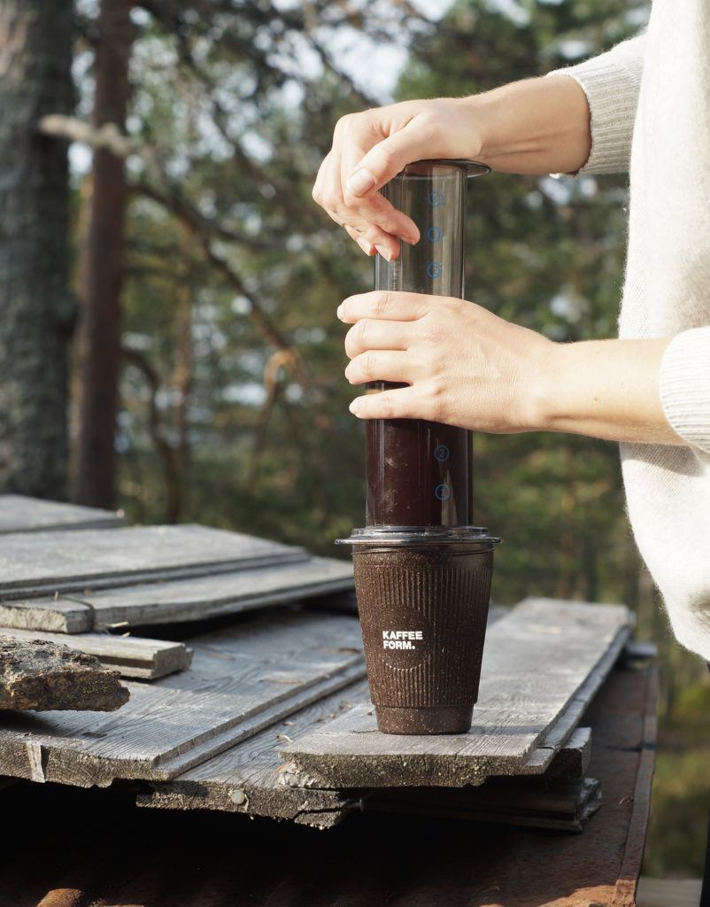 Person drückt Filterkaffee durch einen Aeropress Filter in einen Kaffeeform Weducer Cup