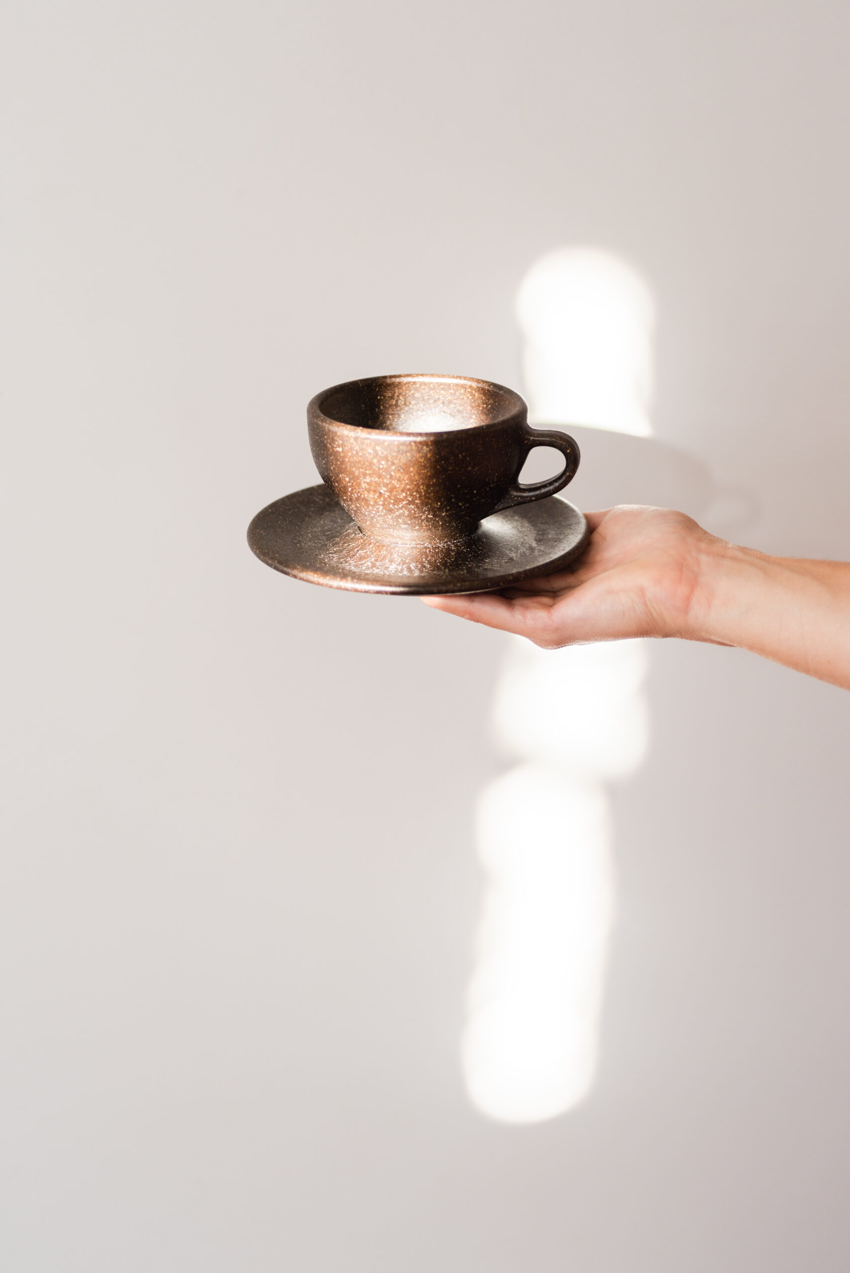 Hand hält Kaffeeform Espresso Cup vor einem weißem Hintergrund