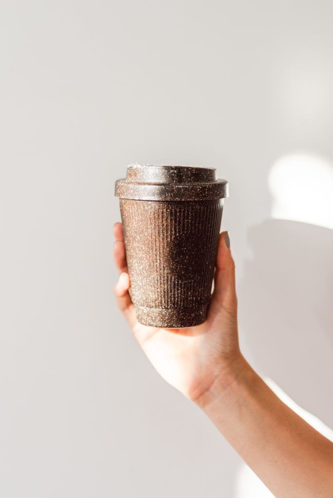 Hand hält Kaffeeform Weducer Cup vor einem weißem Hintergrund