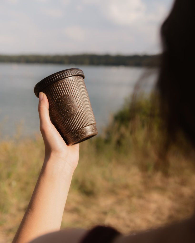 Weducer Cup mit dem Weducer Cap aufgeschraubt vor einem Naturhintergrund